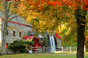 The Wayside Inn Grist Mill with water wheel and cascade water fall in Autumn at sunrise, Sudbury Massachusetts USA