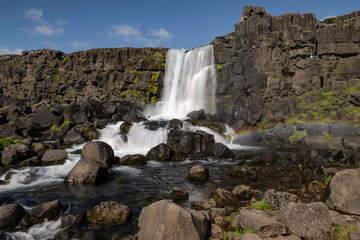 Öxarárfoss Waterfall with a rainbow, located in Thingvellir National Park in Iceland