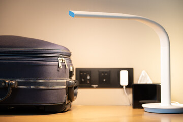 desk with a luminated lamp and luggage