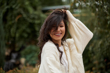 Portrait of pretty asian kazakh brunette woman with charming smile walking along outdoors