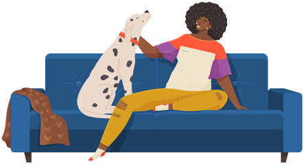 Female pet owner sitting and playing with dog on couch. Caring for animals, joint pastime with pets concept. African lady with domestic animal on sofa. Girl with dalmatian spends time at home