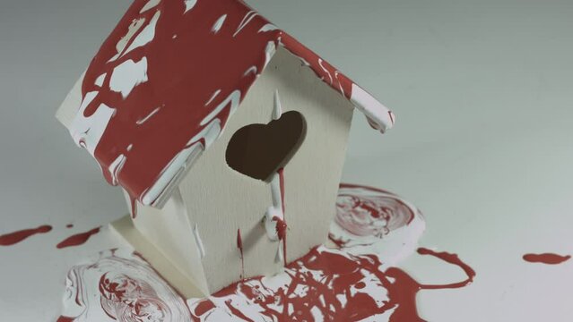 Red and White Paint Pours Onto Wooden Birdhouse 4K
