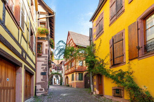 Fototapeta A picturesque street and alley of half-timbered medieval buildings in the historic center of Kaysersberg-Vignoble, France, in the Alsace region.