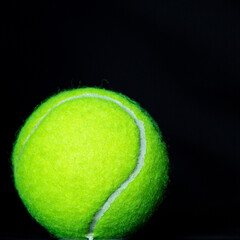 isolated tennis ball on black backdrop