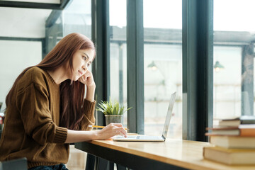 Young woman studying or working online using laptop.