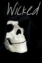 A decorative human skull on a black background. The skull is draped with a black cowl. The word wicked is above.