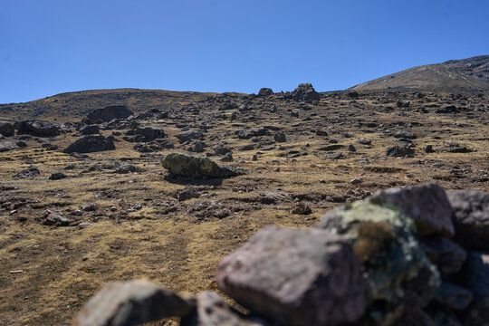 Superficie plana de rocas colocadas aleatoriamente sobre valle de vegetación rural 