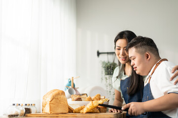 Asian happy family, mature mother baking bakery with son in kitchen. 