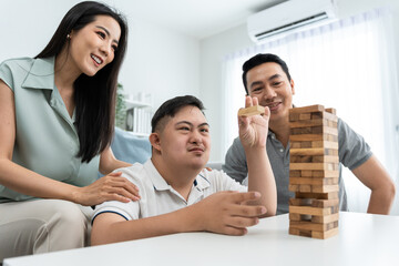 Asian attractive family playing with young son in living room in house. 