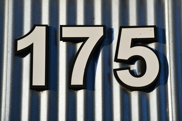 175 white font with corrugated metal background.