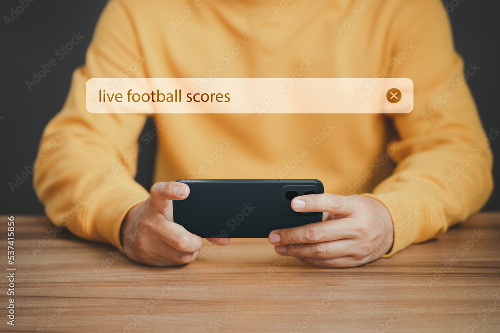Aufkleber football fan's holding smartphone for search live football scores. searching browsing internet data 