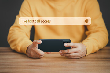 Football fan's holding smartphone for search live football scores. Searching Browsing Internet Data Information with search bar. Search Engine technology networking Concept.