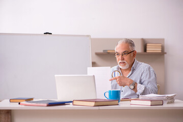 Old male employee working from home during pandemic