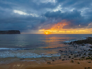 Drizzly moody sunrise seascape with cloud filled sky