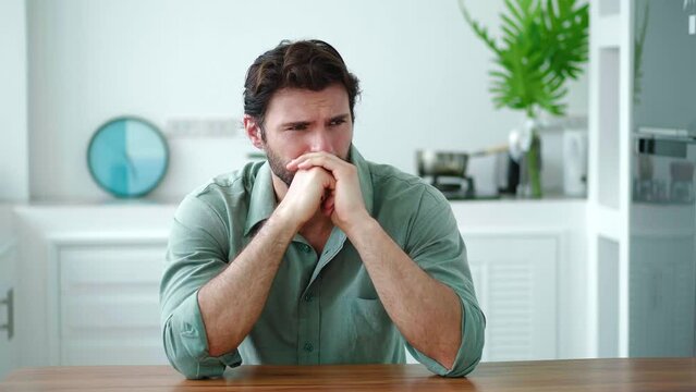 Young bearded dark-haired upset Caucasian man feels disturbance and emotional distress. Mental and psychological health concept. Anxiety Exhaustion Stress Burnout Helplessness Unmotivation Failure