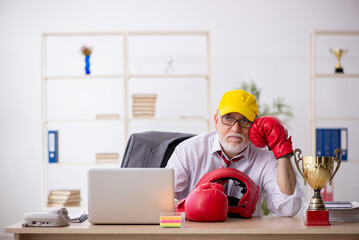 Old male employee boxer being awarded with golden cup