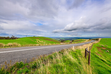 Winding road through Adelaide Hills farms during winter season, South Australia