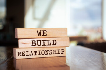 Wooden blocks with words 'WE BUILD RELATIONSHIP'.