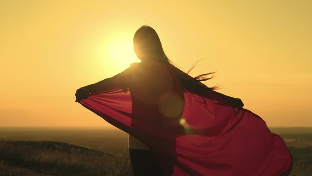 girl superhero sunset glare. game teenager red raincoat top mountain. glare sun sky. brave superhero meets day dawn. children dream.girl red raincoat wind. superhero costume. child pray wind sun.