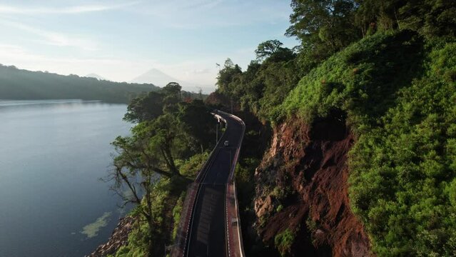 winding road to adventures lakeside bridge lake and cliffs with mountains horizon and driving car ride van going camping Bali, Indonesia