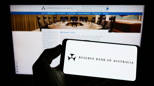 Stuttgart, Germany - 10-01-2022: Person holding cellphone with logo of issuer Reserve Bank of Australia (RBA) on screen in front of business webpage. Focus on phone display.