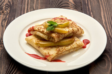 delicious juicy pancakes drizzled with sauce are served on a white plate