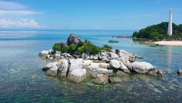 aerial of rocky islet on coast of lengkuas island in belitung on sunny summer day