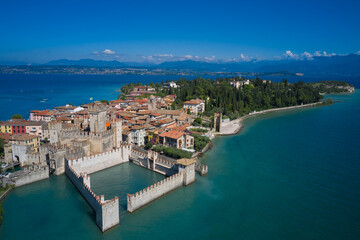 Fototapeta na wymiar Tourist destination in Lombardy region of Italy. Aerial view on Sirmione sul Garda. Italy, Lombardy. Rocca Scaligera Castle in Sirmione. Aerial photography with drone.
