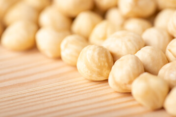 Macro photo of hazelnuts on wooden table. Fresh tasty peeled hazelnuts ready to eat