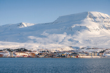 Along the way around Reydarfjordur , ports town close to the sea and snow mountain during winter sunny day at Reyðarfjörður , Fjord town on Eastern Coast of Iceland  : 19 March 2020