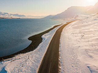 Along the way around Reydarfjordur , ports town close to the sea and snow mountain during winter sunny day at Reyðarfjörður , Fjord town on Eastern Coast of Iceland  : 19 March 2020