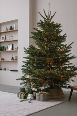 Huge Christmas tree with lights. Minimalistic Christmas decorations at home. New year background. Holidays celebration.