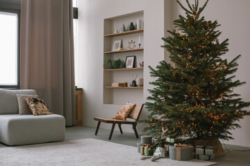 Modern minimalistic living room with beautiful huge Christmas tree and wrapped gifts. Scandinavian...