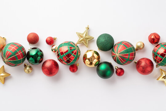 Christmas decorations concept. Top view photo of red green gold baubles balls and star ornaments on isolated white background