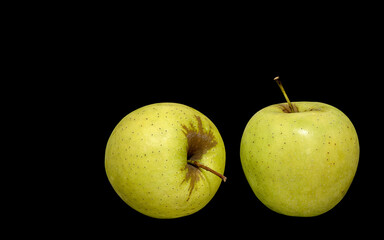  two ripe green apples on a black background