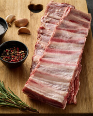 Raw pork ribs with spices, salt, pepper and rosemary. Fresh pork. Pig ribs.