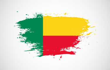 Obraz premium Grunge brush stroke with the national flag of Benin on a white isolated background