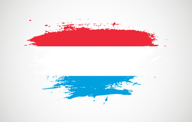 Grunge brush stroke with the national flag of Luxembourg on a white isolated background