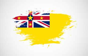 Grunge brush stroke with the national flag of Niue on a white isolated background