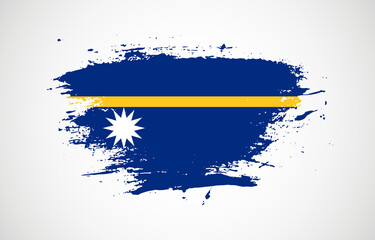 Grunge brush stroke with the national flag of Nauru on a white isolated background