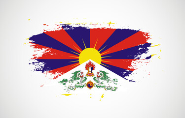 Grunge brush stroke with the national flag of Tibet on a white isolated background