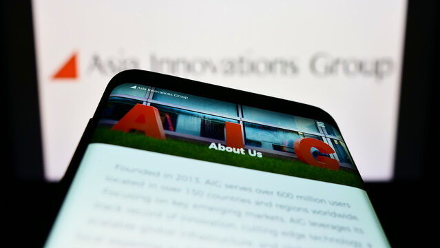 Stuttgart, Germany - 10-01-2022: Mobile phone with website of Internet company Asia Innovations Group (AIG) on screen in front of logo. Focus on top-left of phone display.