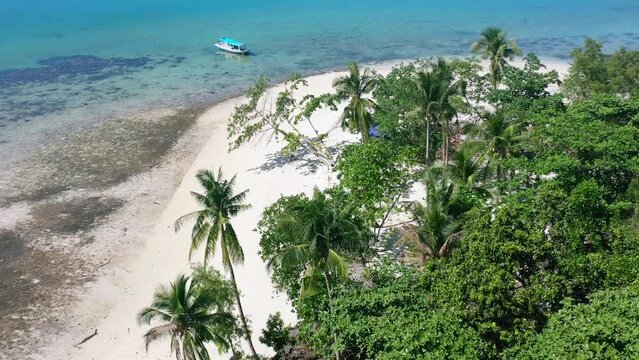 aerial of empty white sand beach and boat anchored on tropical island in belitung indonesia