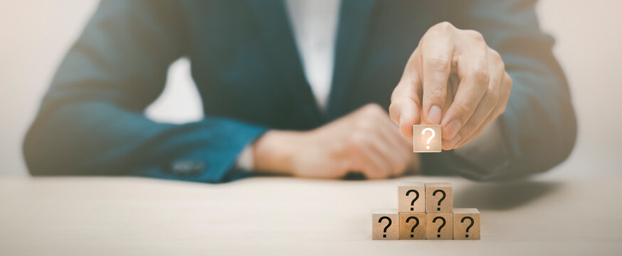 Hand Hold Wooden Cube Block In Question Mark Mean What On Cement Table Background, Column Of Wooden Blocks With Question Sign Mark. Copy Space,FAQ Frequently Asked Questions, Answer, Information