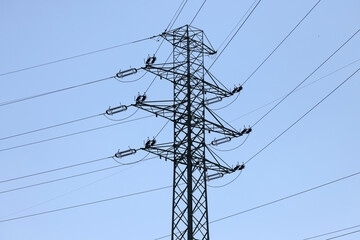 high voltage power pole and lines against the blue sky