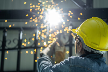 Asian handyman welding and grinding steel at his workplace As sparks flew around him. He wears a...