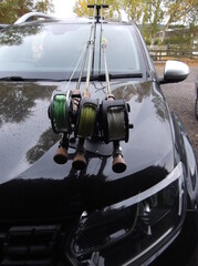 Fishing rods attached to a car bonnet in a fishing rod carrier - 537447022