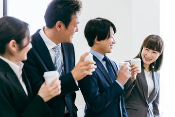 コーヒーを飲みながら休憩するビジネスマンとビジネスウーマン
