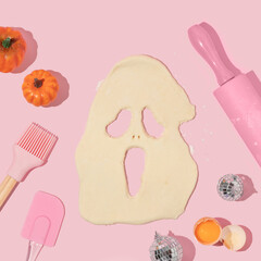 Halloween creative layout with  glass of dough forming ghost with pumkins and kitchen utensils on...