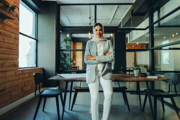 Happy young business woman wearing a hijab in an office
